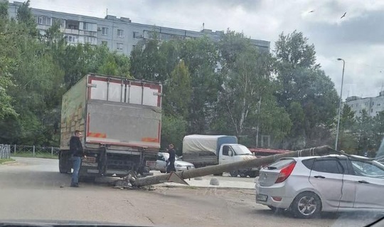 Грузовик уронил столб на легковушку на Адоратского. 
 
Водитель фургона сдавал назад и не заметил фонарный..